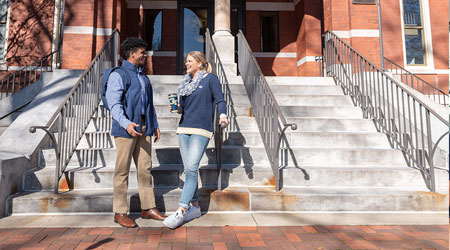 students talking at the base of some stairs